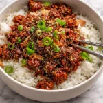 A colorful plate of quick Asian inspired meals featuring chicken, rice, and vegetables.